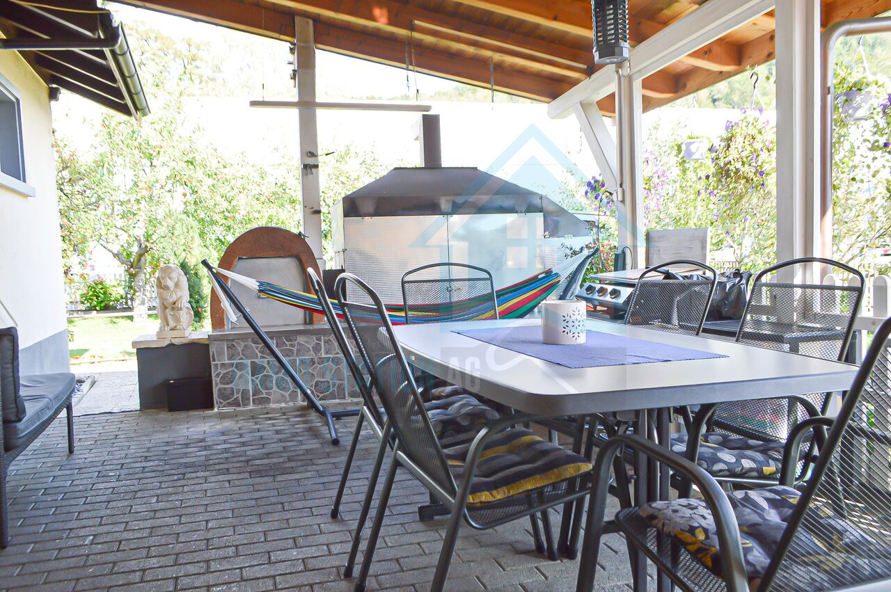 Überdachte Terrasse mit Grill und Essbereich