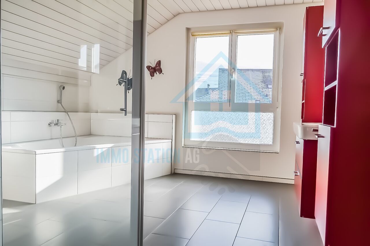 Helles Badezimmer mit Badewanne und Dachfenster