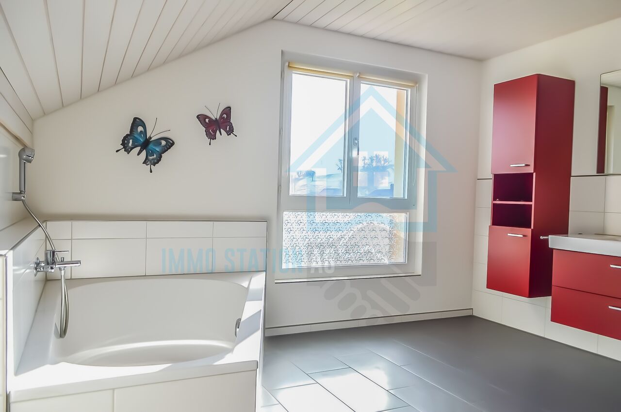 Modernes Badezimmer mit Dachfenster und roten Badmöbeln