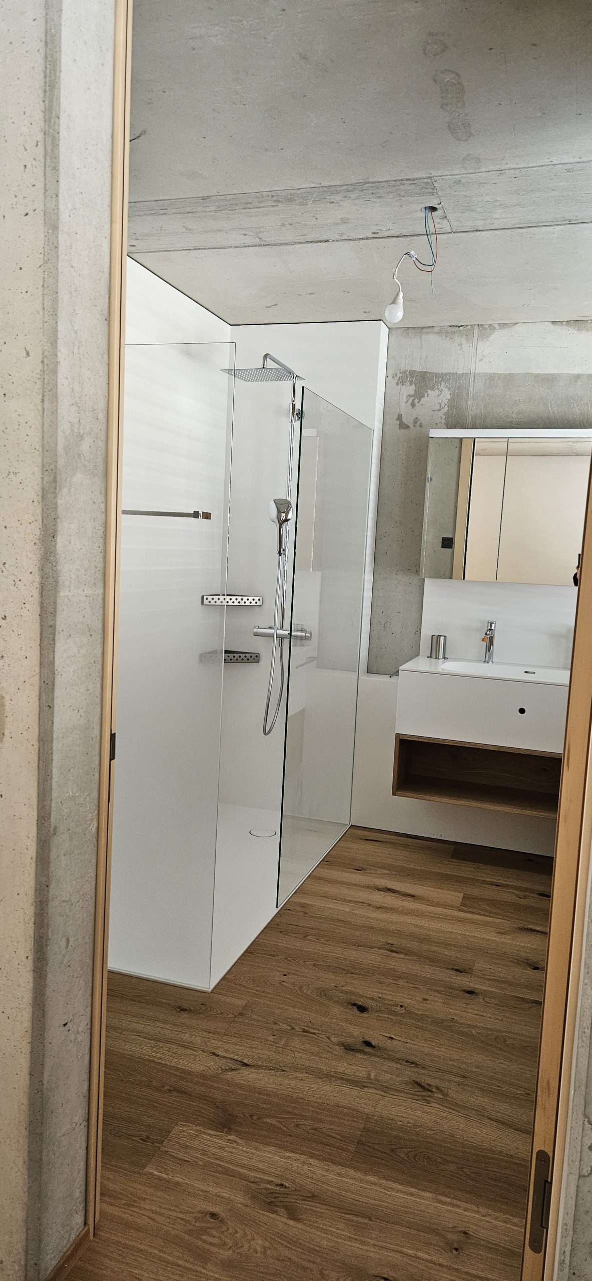 Modernes Bad mit Sichtbeton und Holzoptik