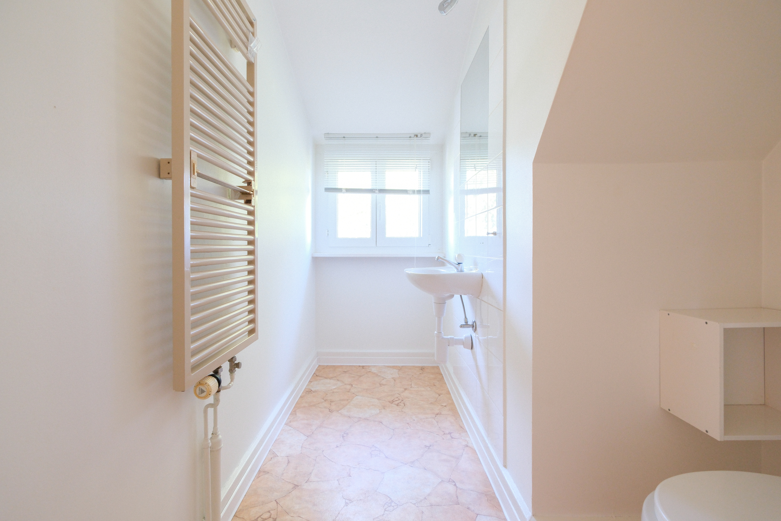 Helles kleines Badezimmer mit Fenster und Heizkörper
