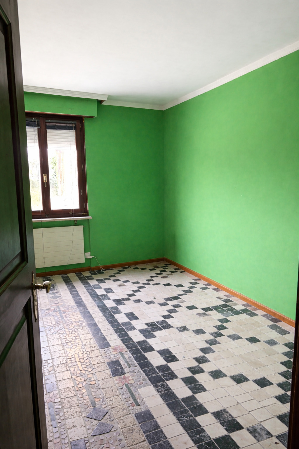 Leerer Raum mit grüner Wand und gemustertem Fliesenboden
