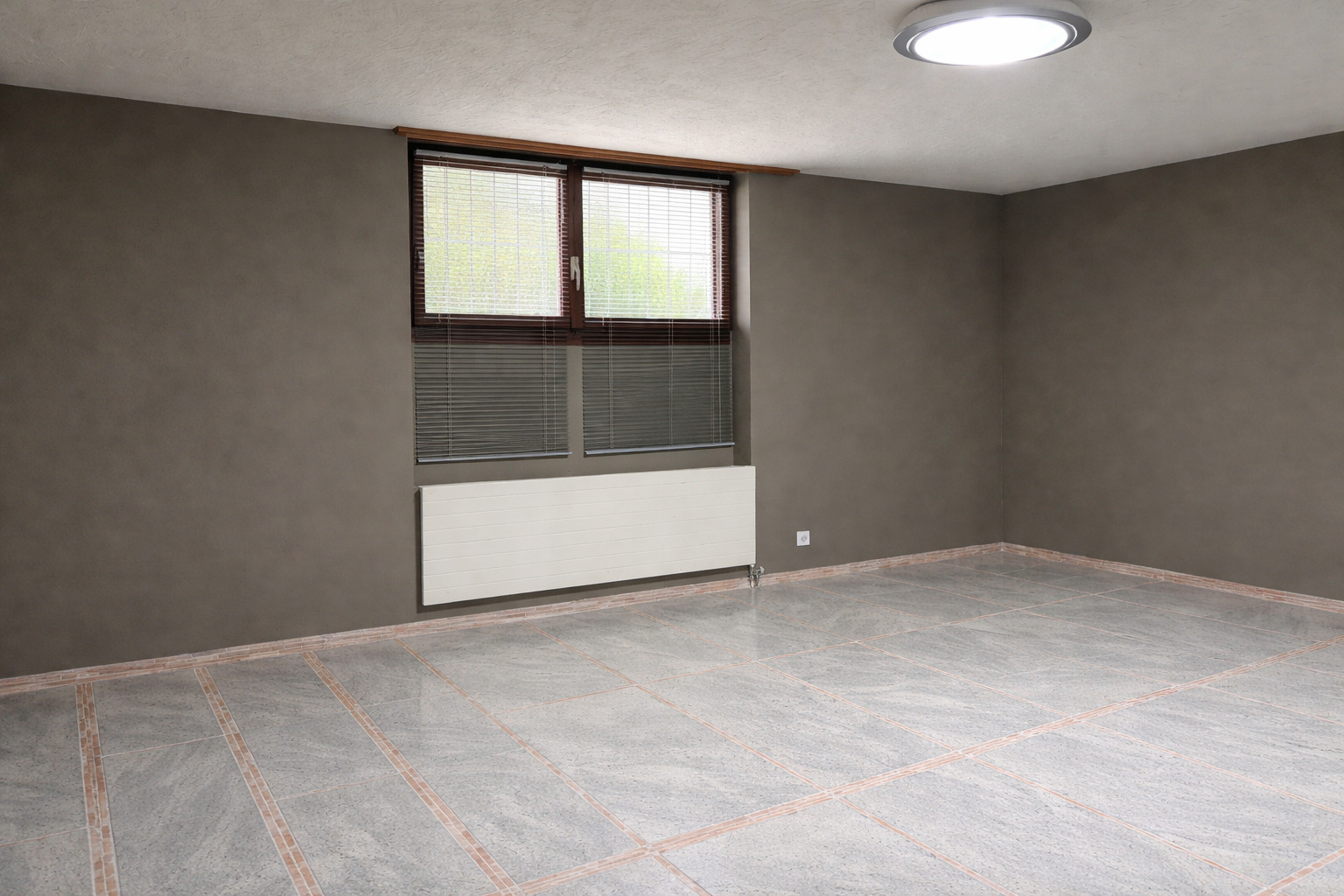 Leerer Innenraum mit Fenster und Heizkörper