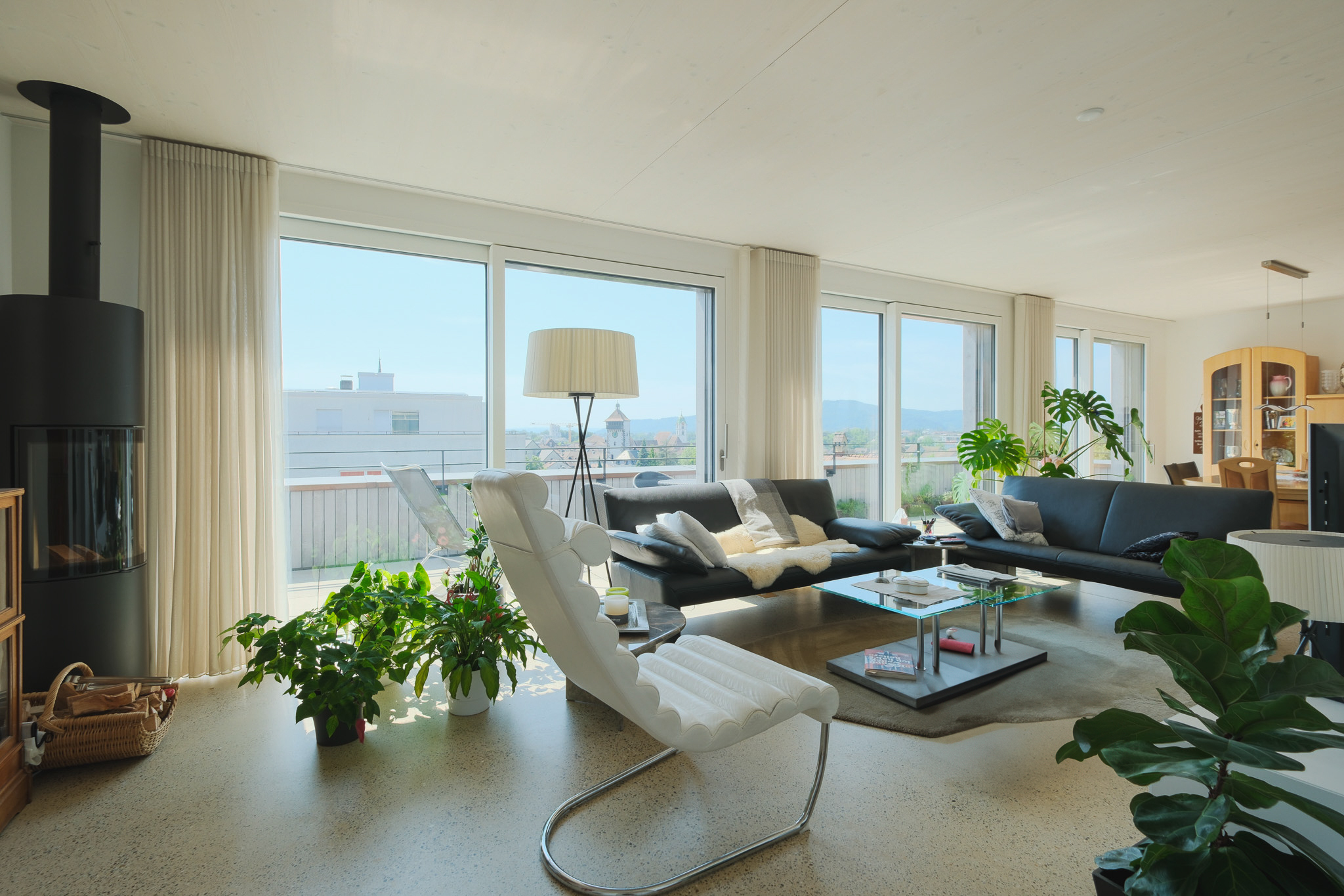 Helles Wohnzimmer mit Panoramafenstern und Blick ins Freie