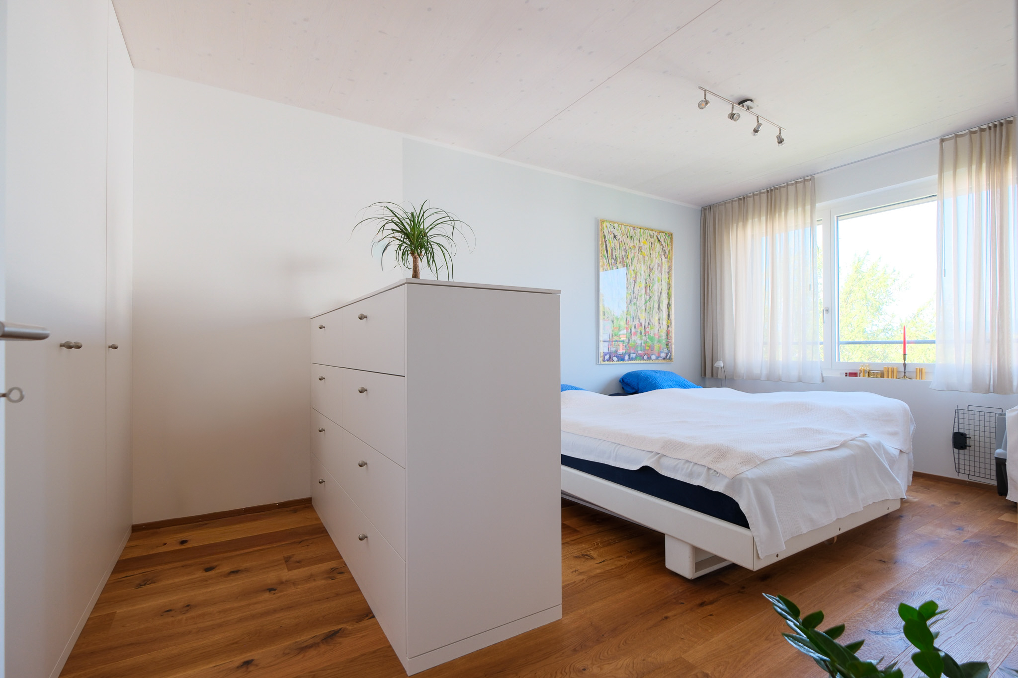 Helles Schlafzimmer mit Einbauschrank und Holzboden