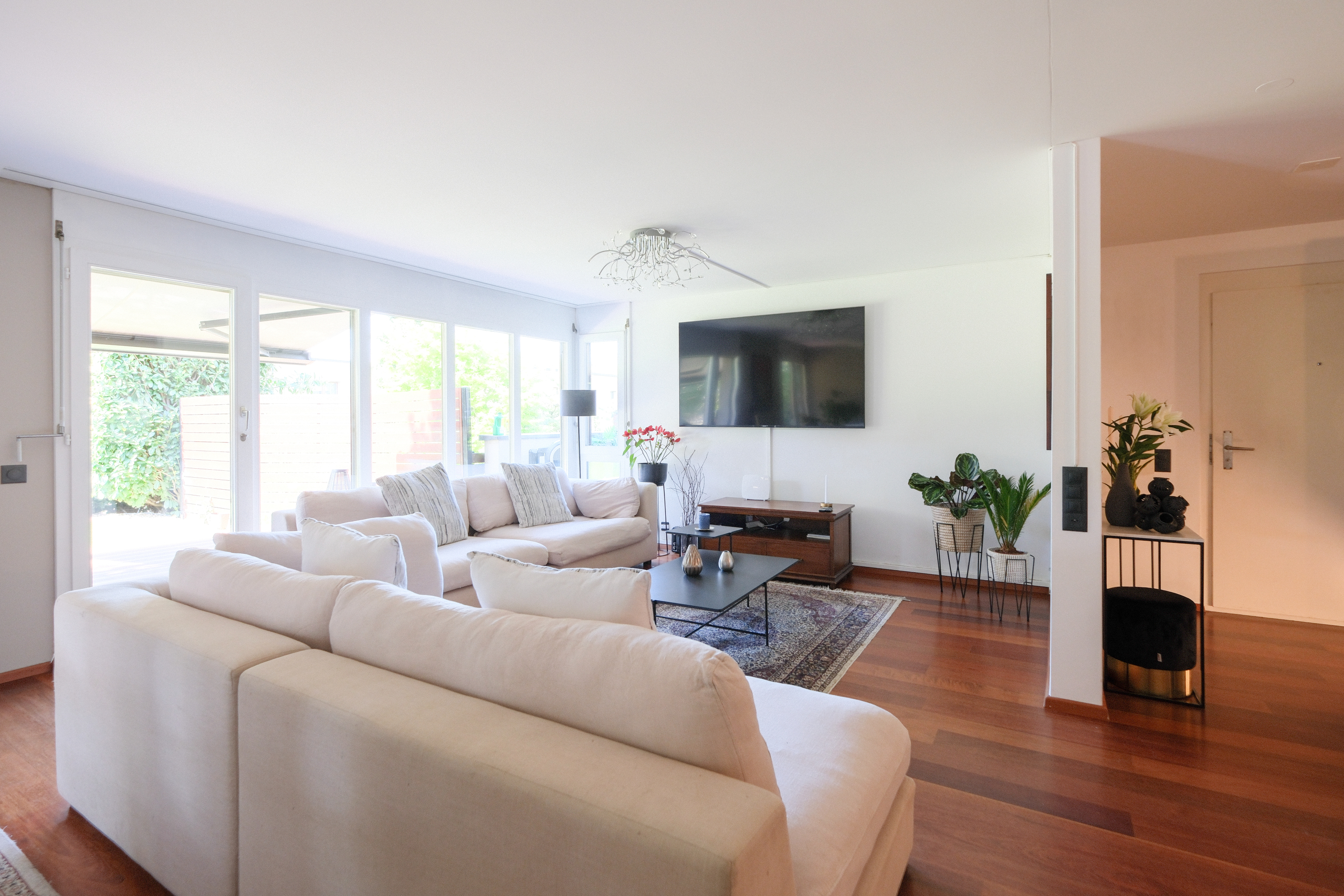Helles Wohnzimmer mit Sofa und Wandfernseher