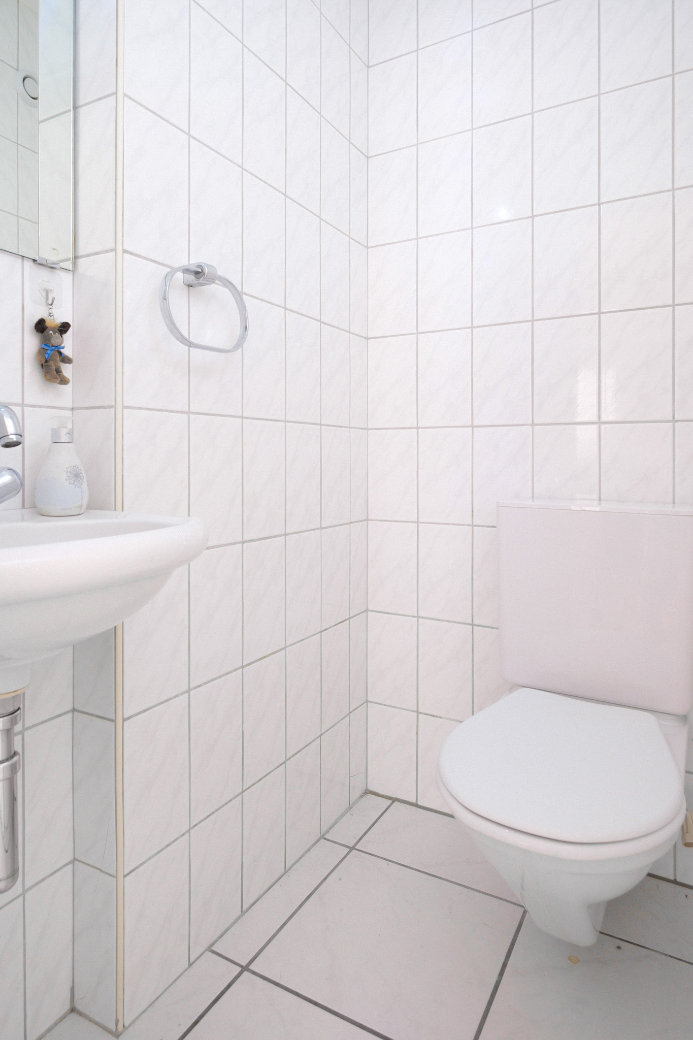 Kleines WC mit weißen Fliesen