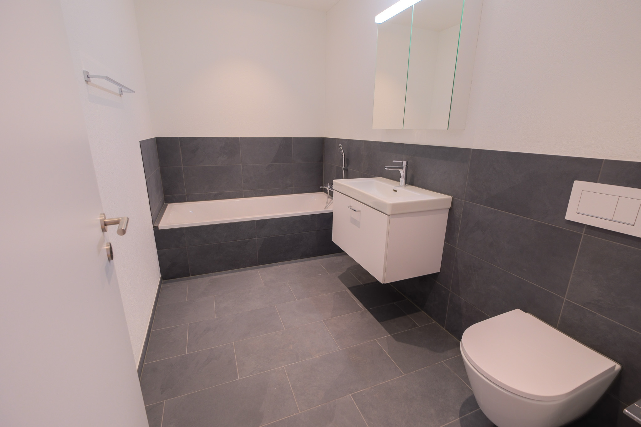 Modernes Badezimmer mit Badewanne, Waschtisch und Wand-WC