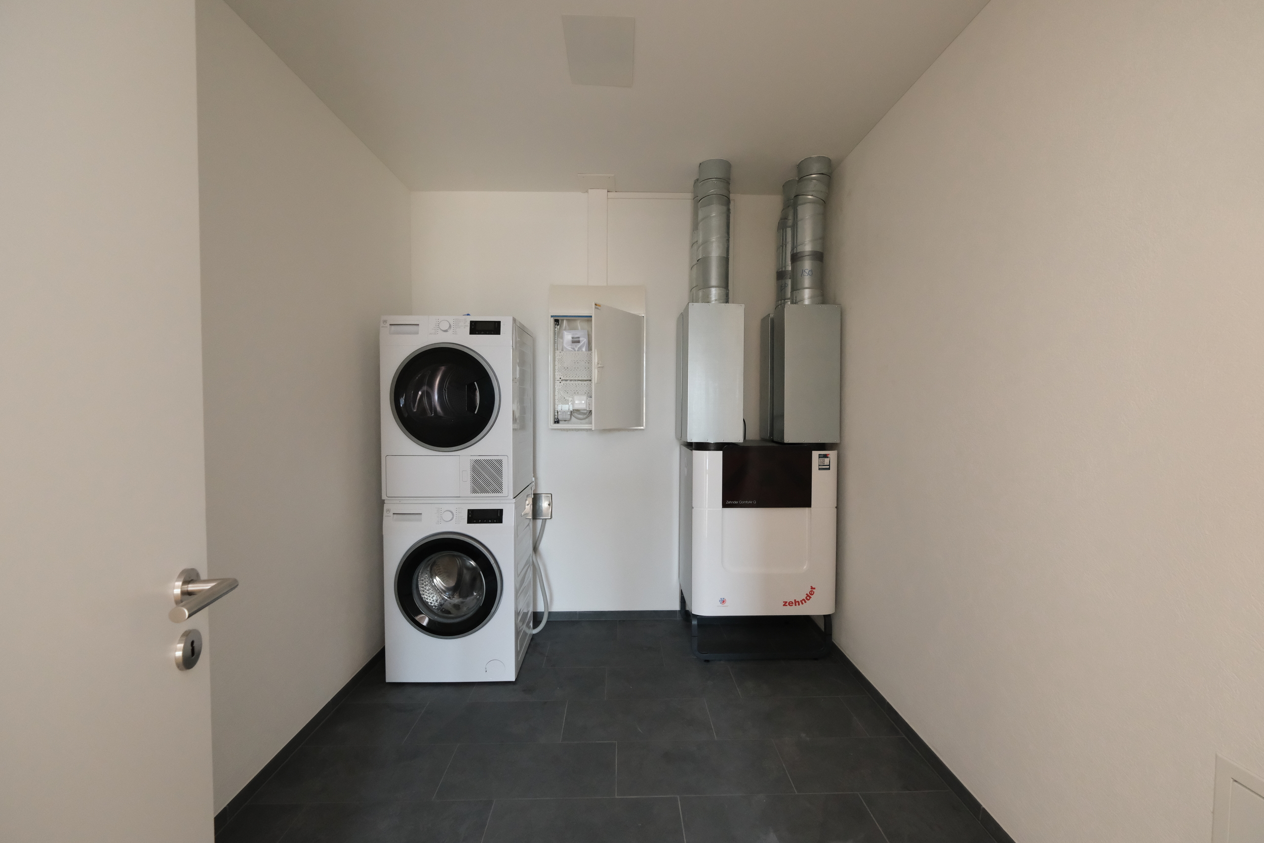Hauswirtschaftsraum mit Trockner, Waschmaschine und Lüftungsanlage