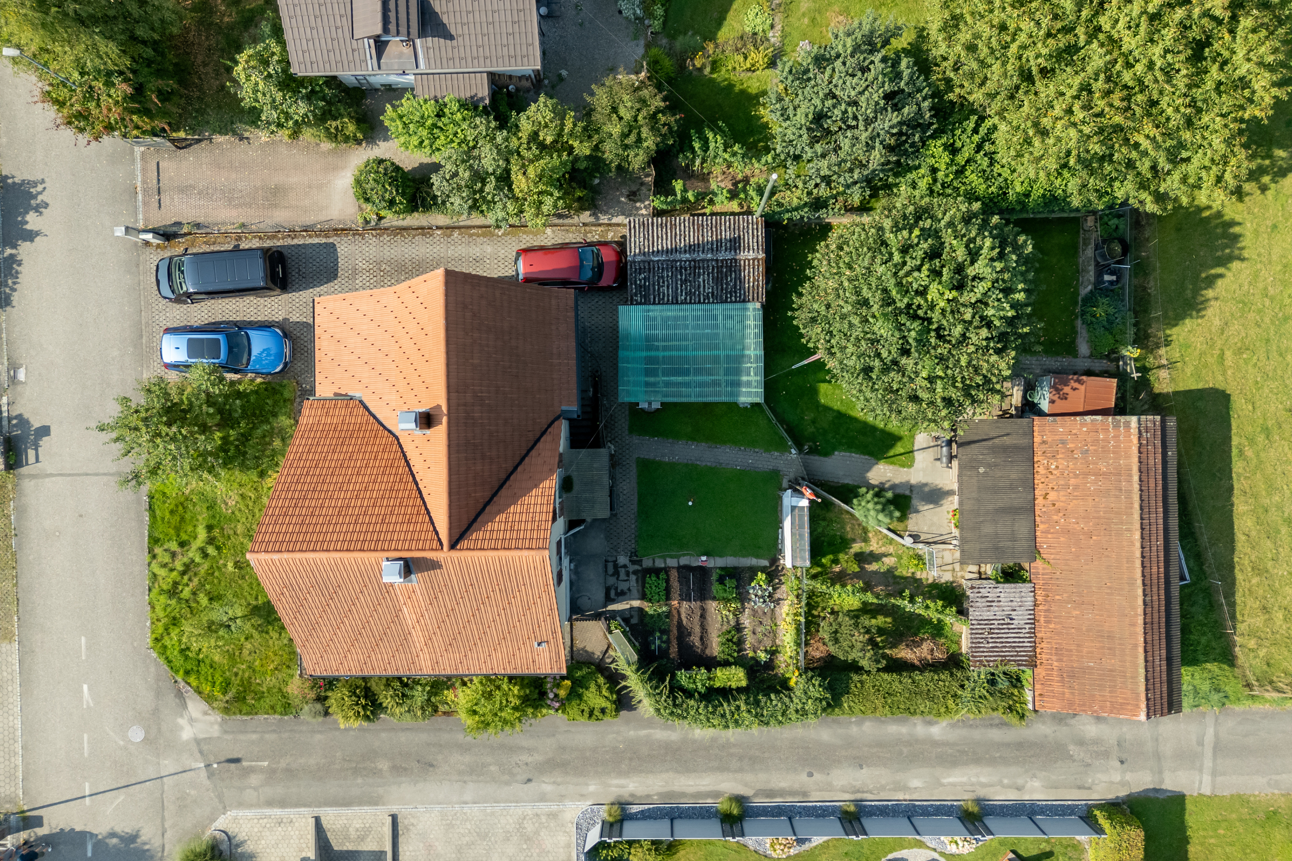 Drohnenaufnahme eines Wohnhauses mit Garten und Nebengebäuden
