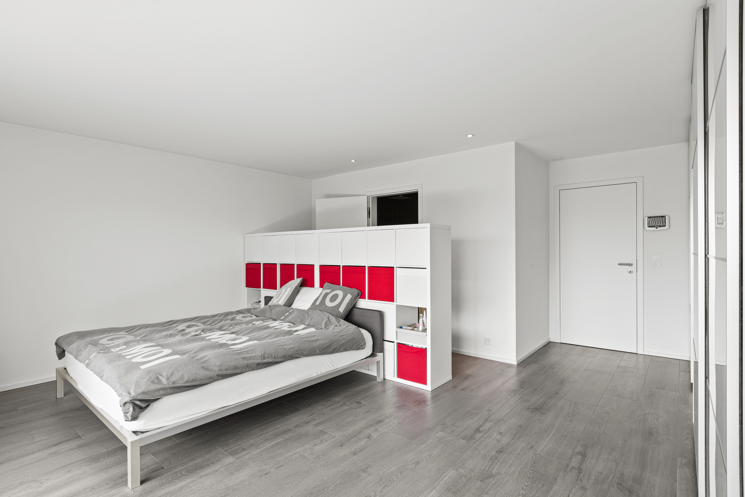 Modernes Schlafzimmer mit viel Weiß und grauem Boden