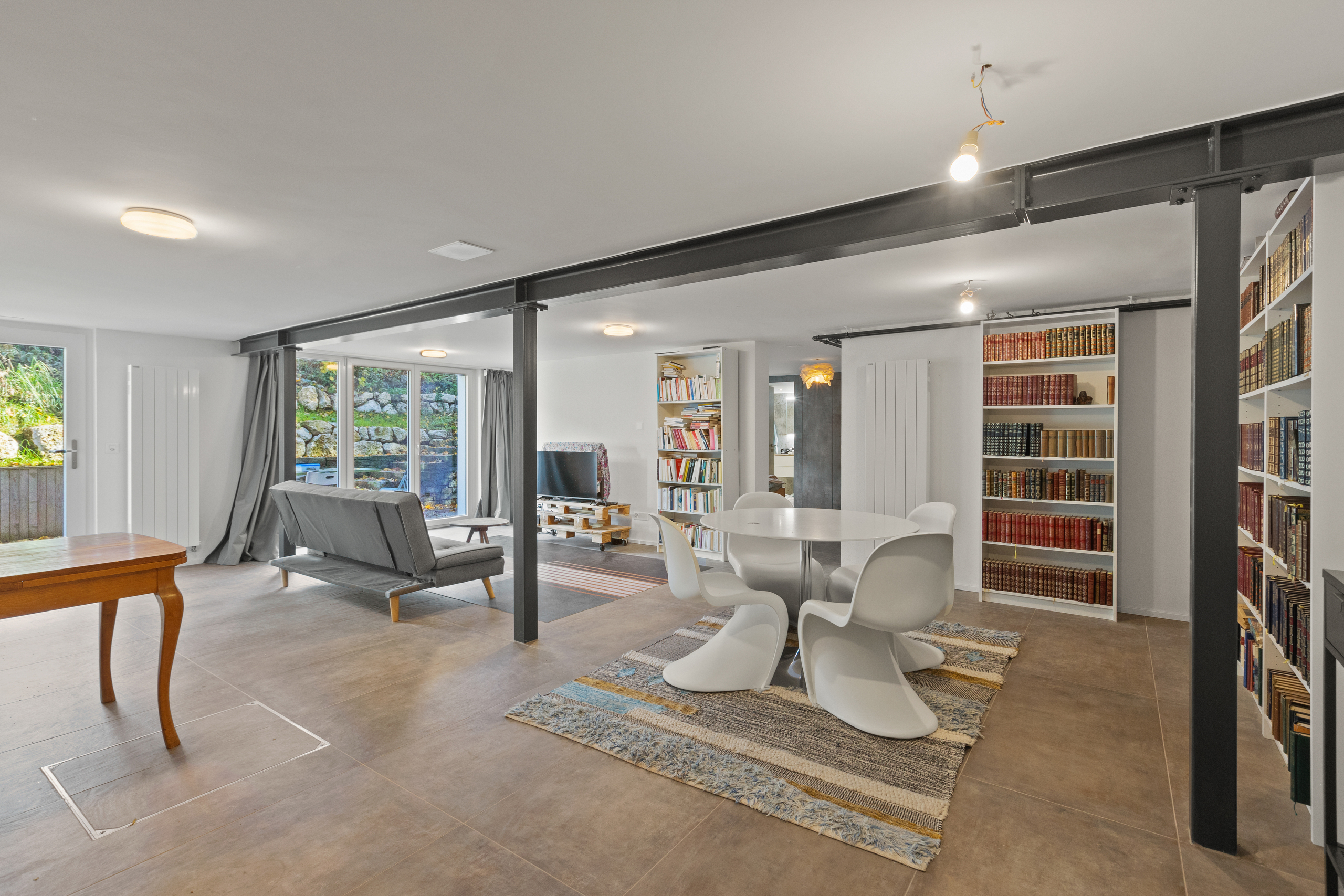 Großer, modern gestalteter Wohn- und Essbereich mit Bibliothekswand
