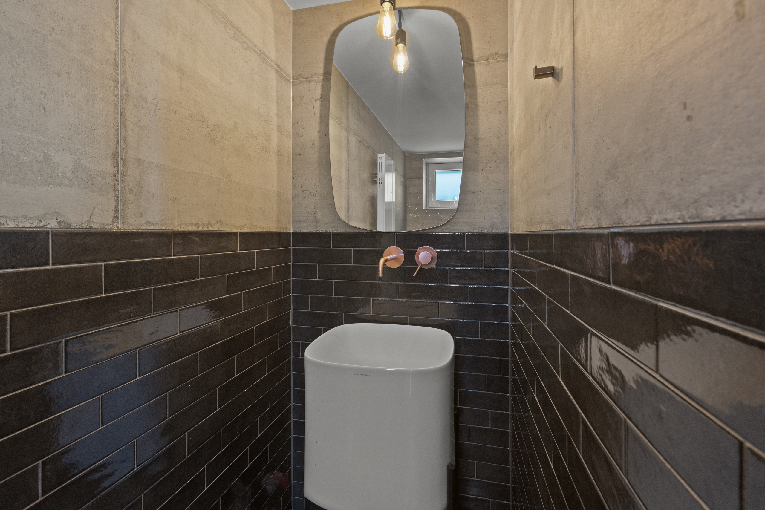 Modernes Gäste-WC mit dunkler Wandverkleidung