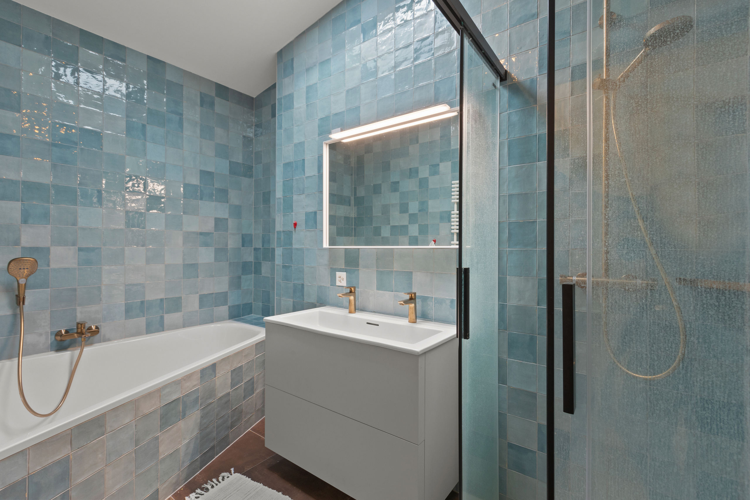 Modernes Badezimmer mit blau gefliesten Wänden