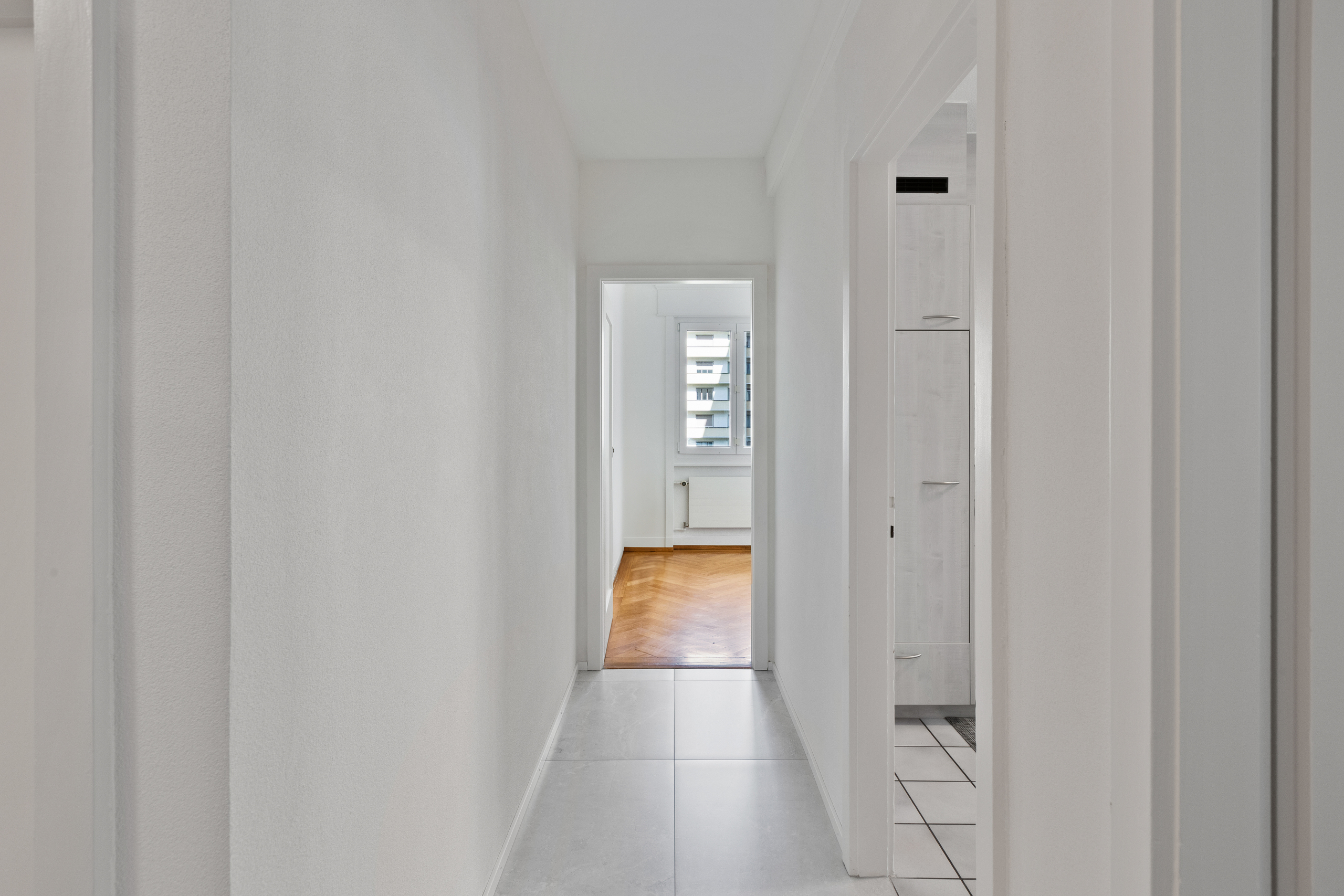 Langer heller Flur mit Blick ins Zimmer