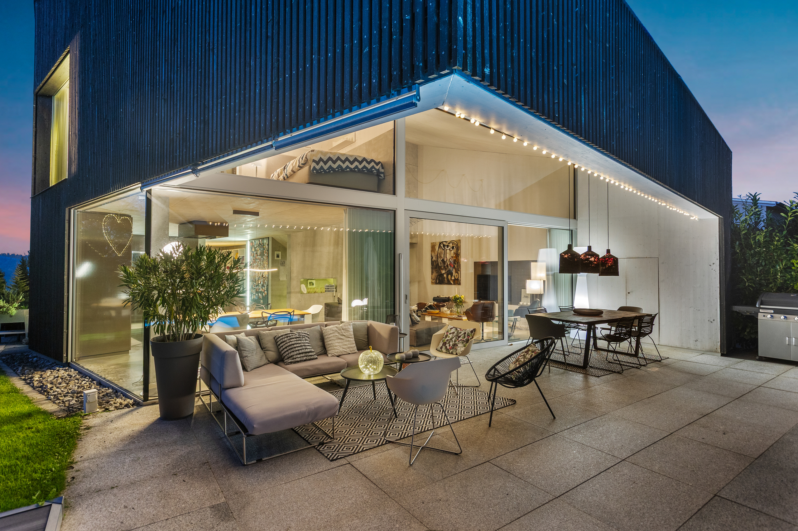 Moderne Hausfassade mit Terrasse am Abend