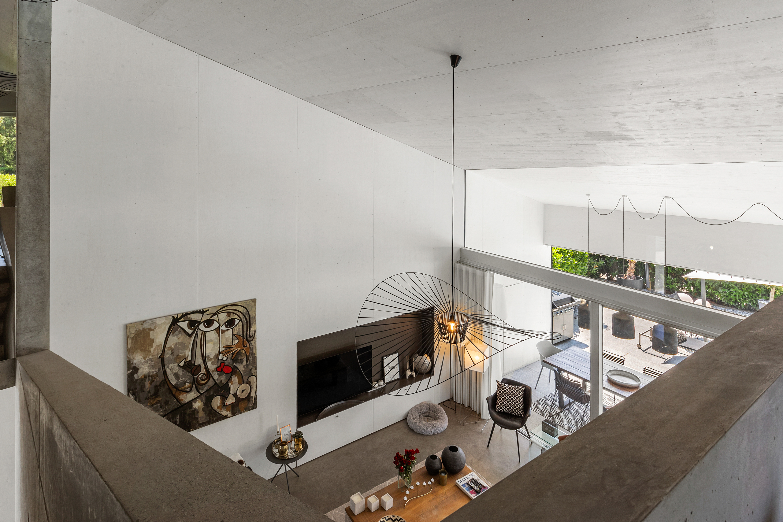 Modernes Wohnzimmer mit Galerie und Patio-Blick