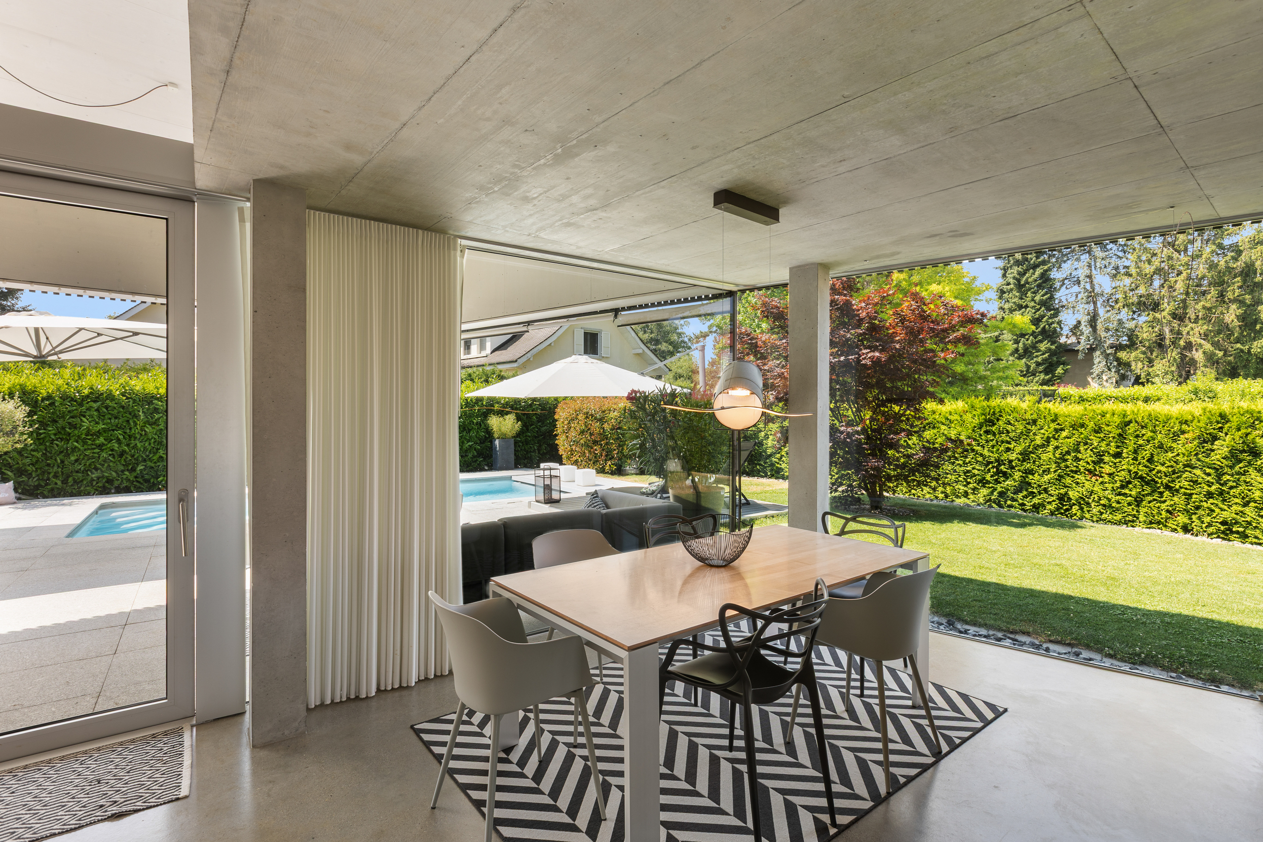 Moderner Essbereich mit Garten- und Poolblick