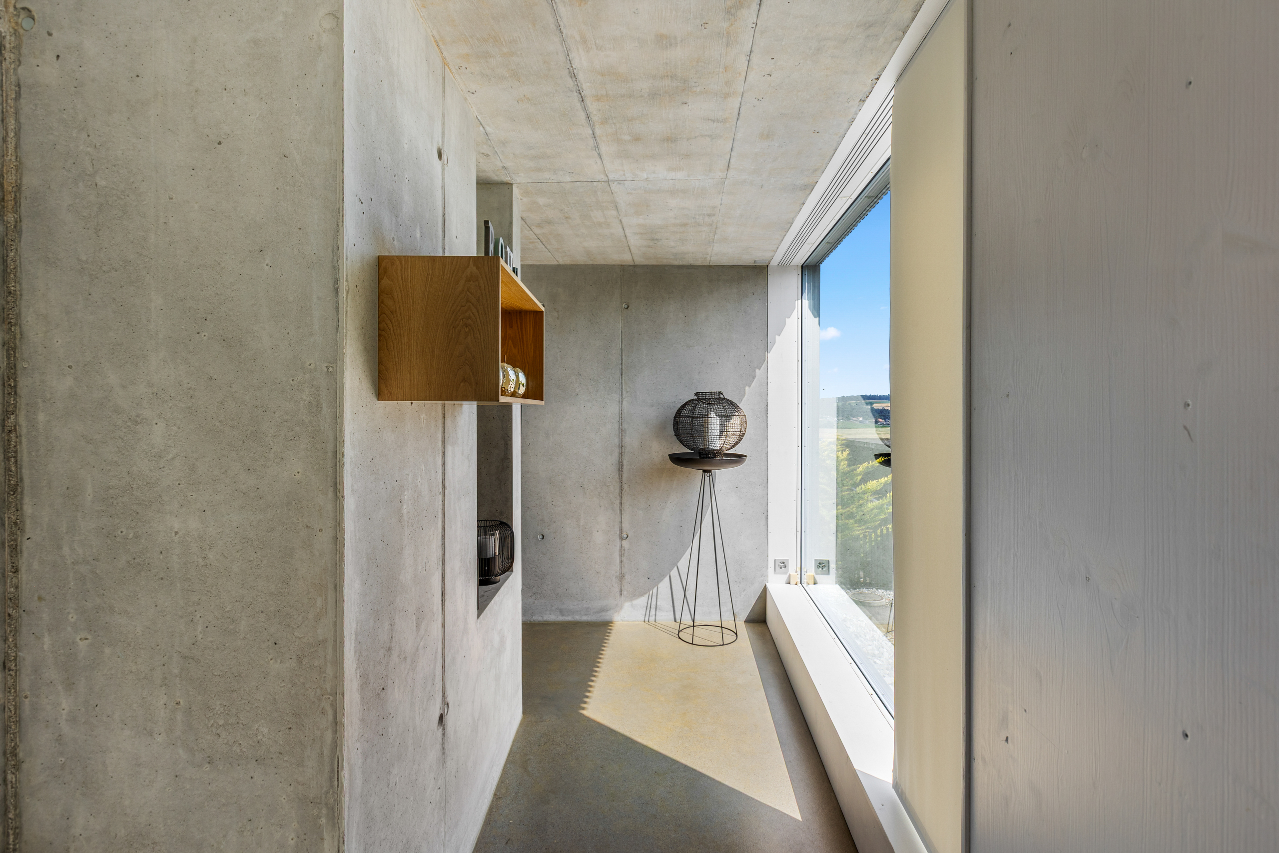 Moderner Innenraum mit Sichtbeton und Fensterfront