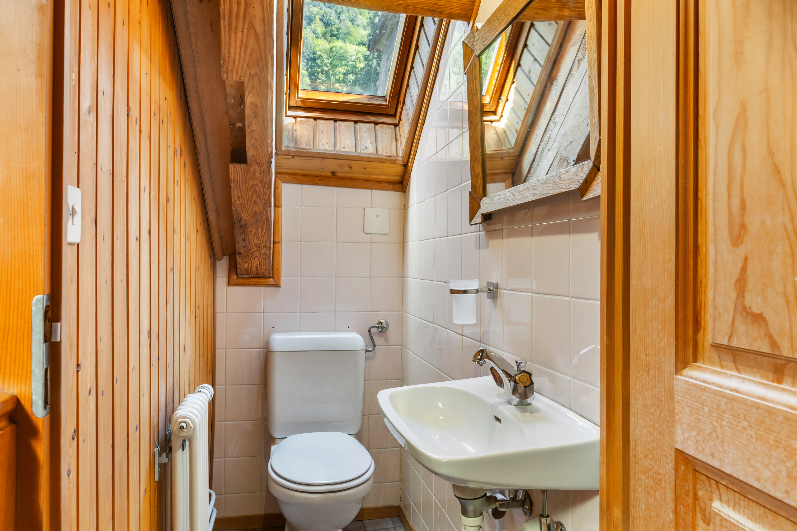Kleines WC mit Holzvertäfelung und Dachfenstern