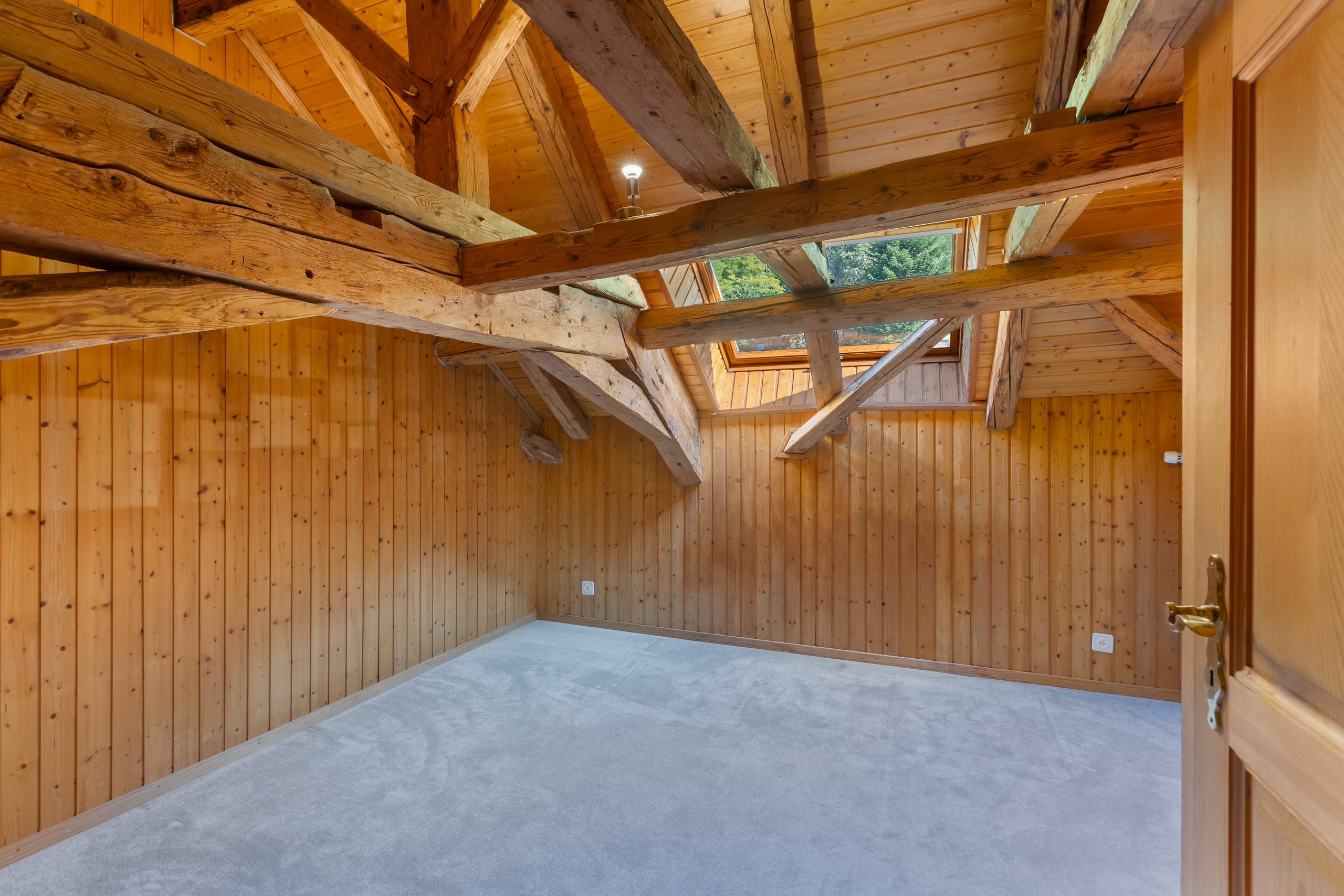 Dachgeschossraum mit sichtbaren Holzbalken