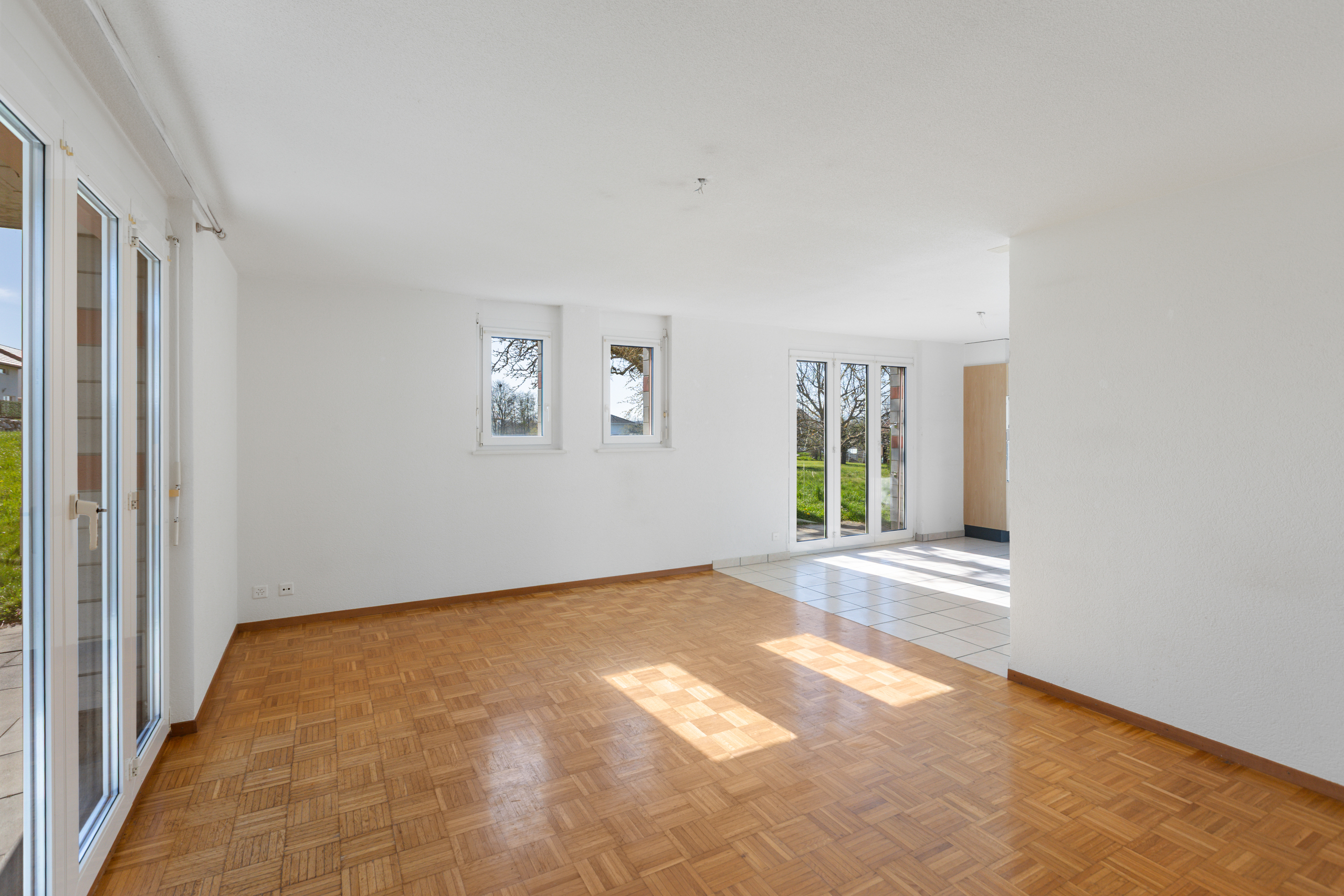 Heller leerer Wohnraum mit Parkett und Fliesen