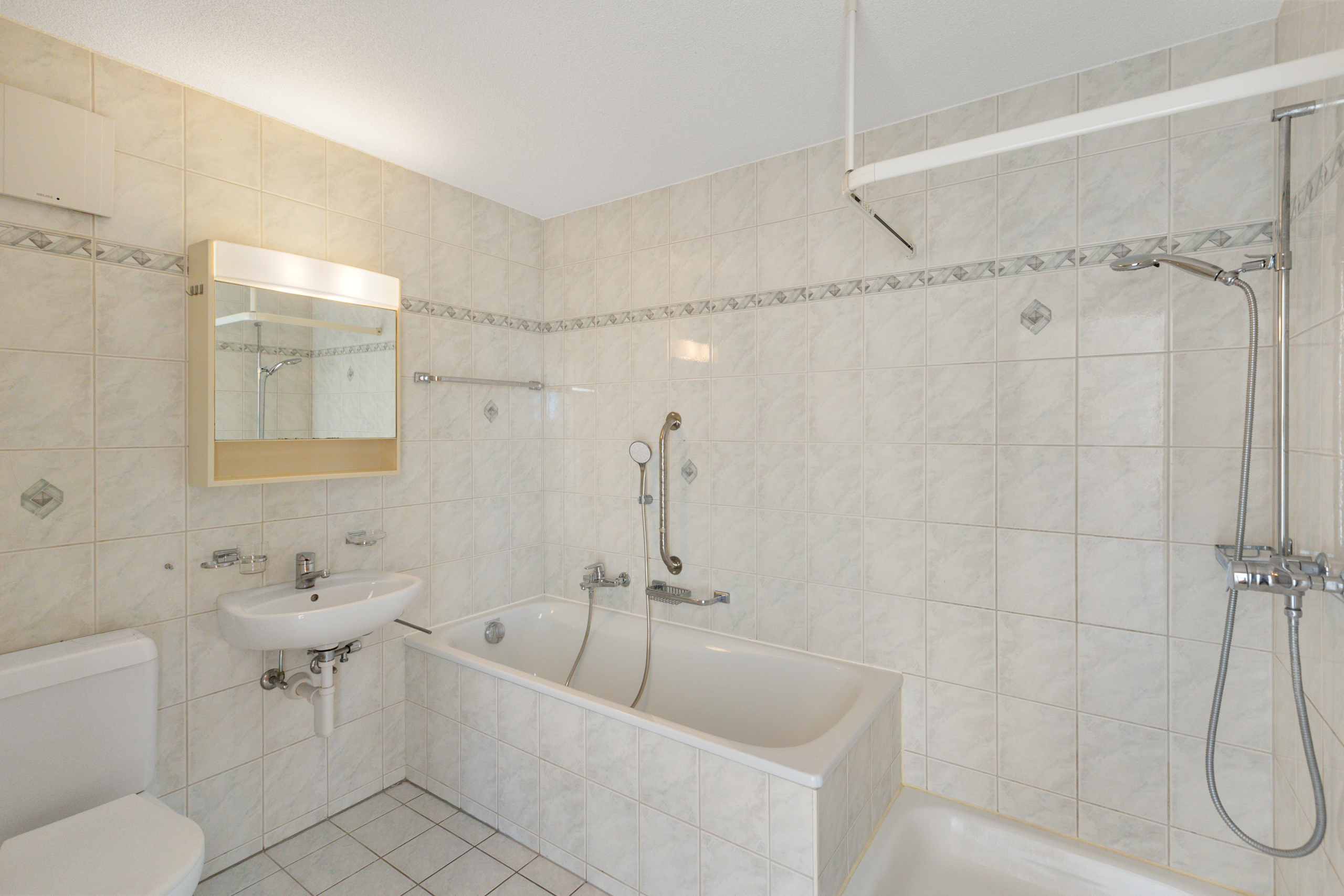 Badezimmer mit Badewanne und Duschbereich