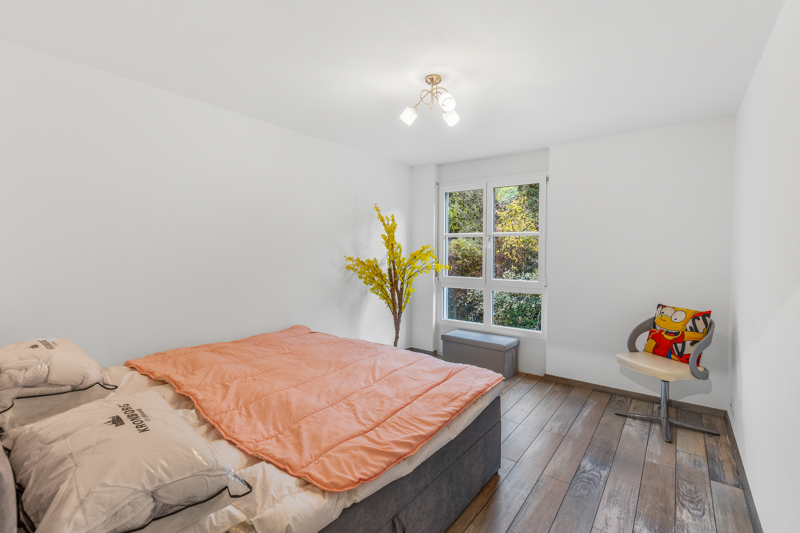 Helles Schlafzimmer mit Bett und Fenster