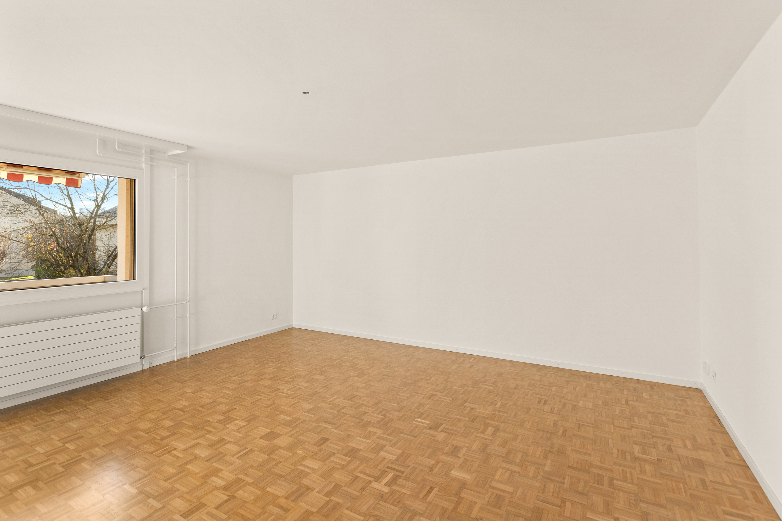 Leerer Wohnraum mit Parkettboden