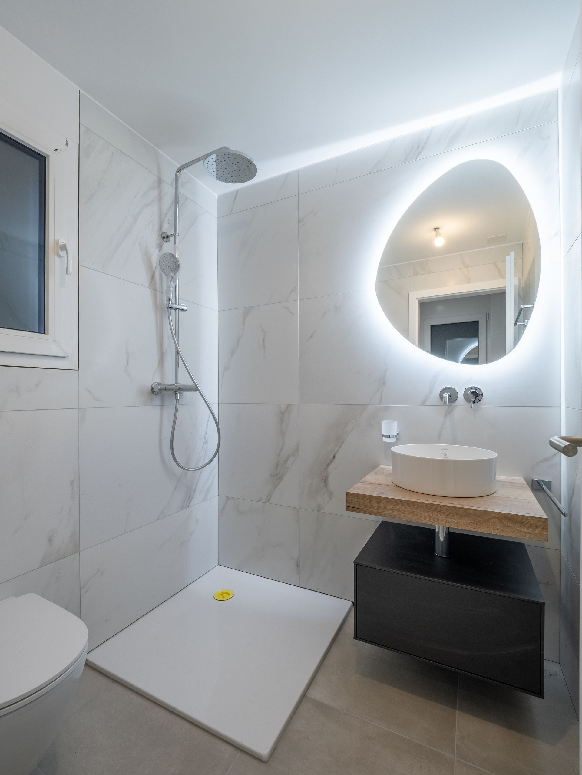 Modernes Bad mit begehbarer Dusche und beleuchtetem Spiegel