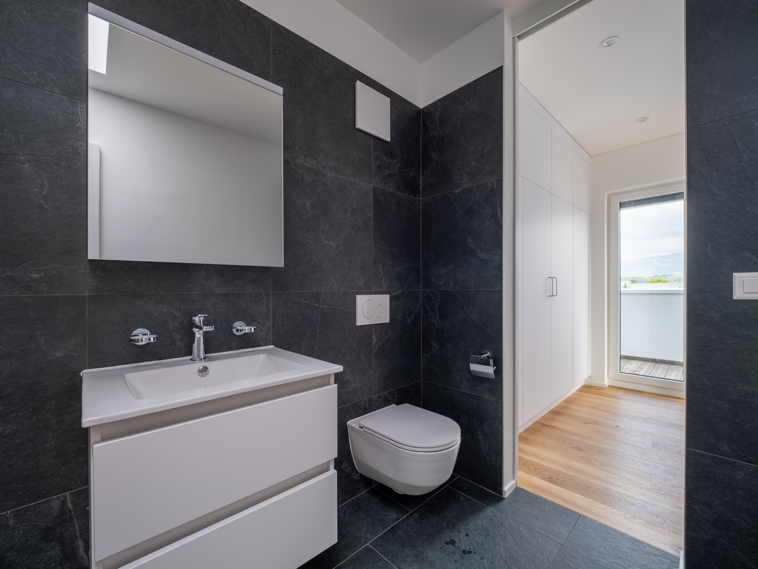Modernes Badezimmer mit Gäste-WC und Blick in den Nebenraum