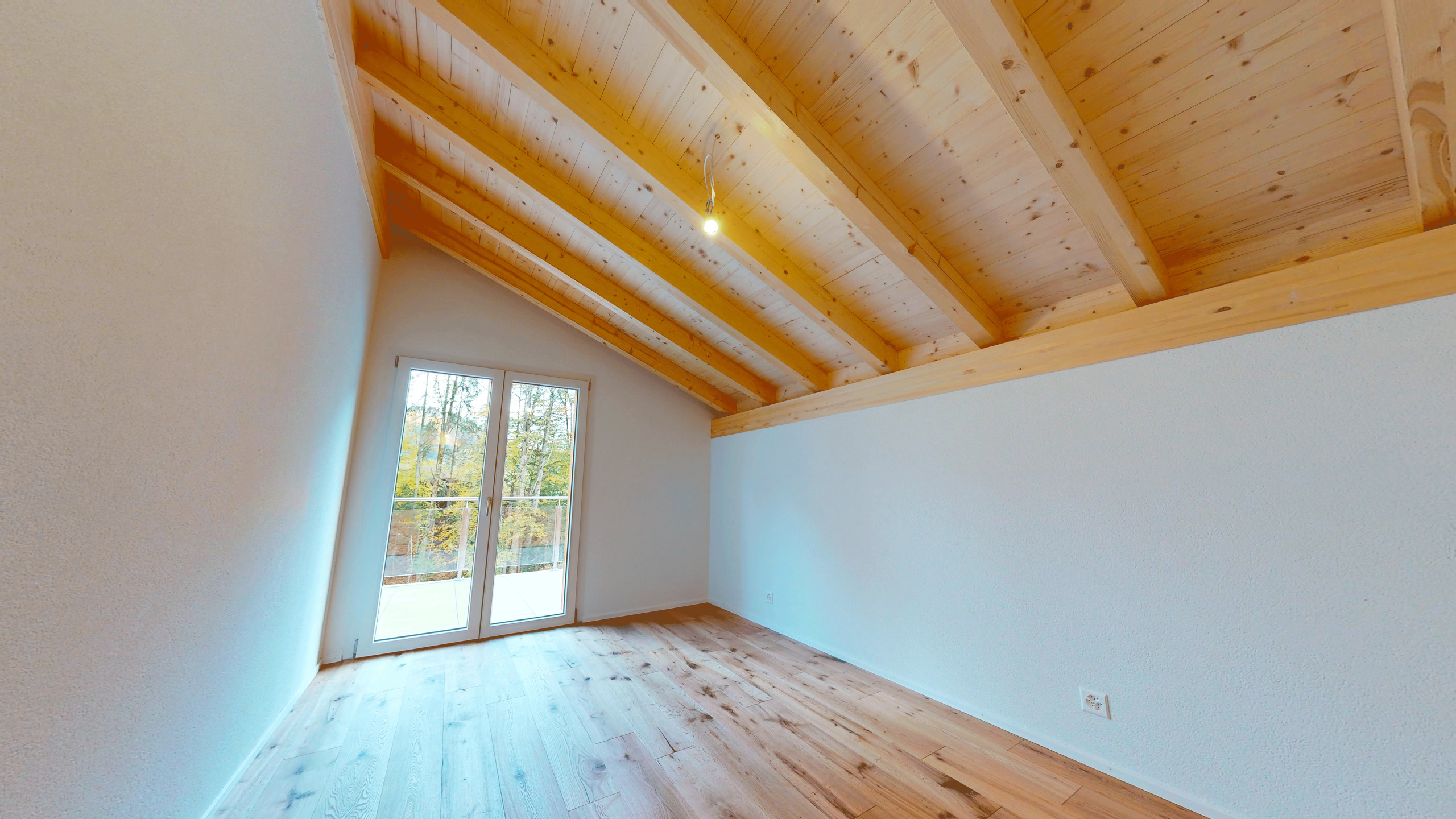 Heller Dachraum mit Holzbalkendecke und Balkonzugang