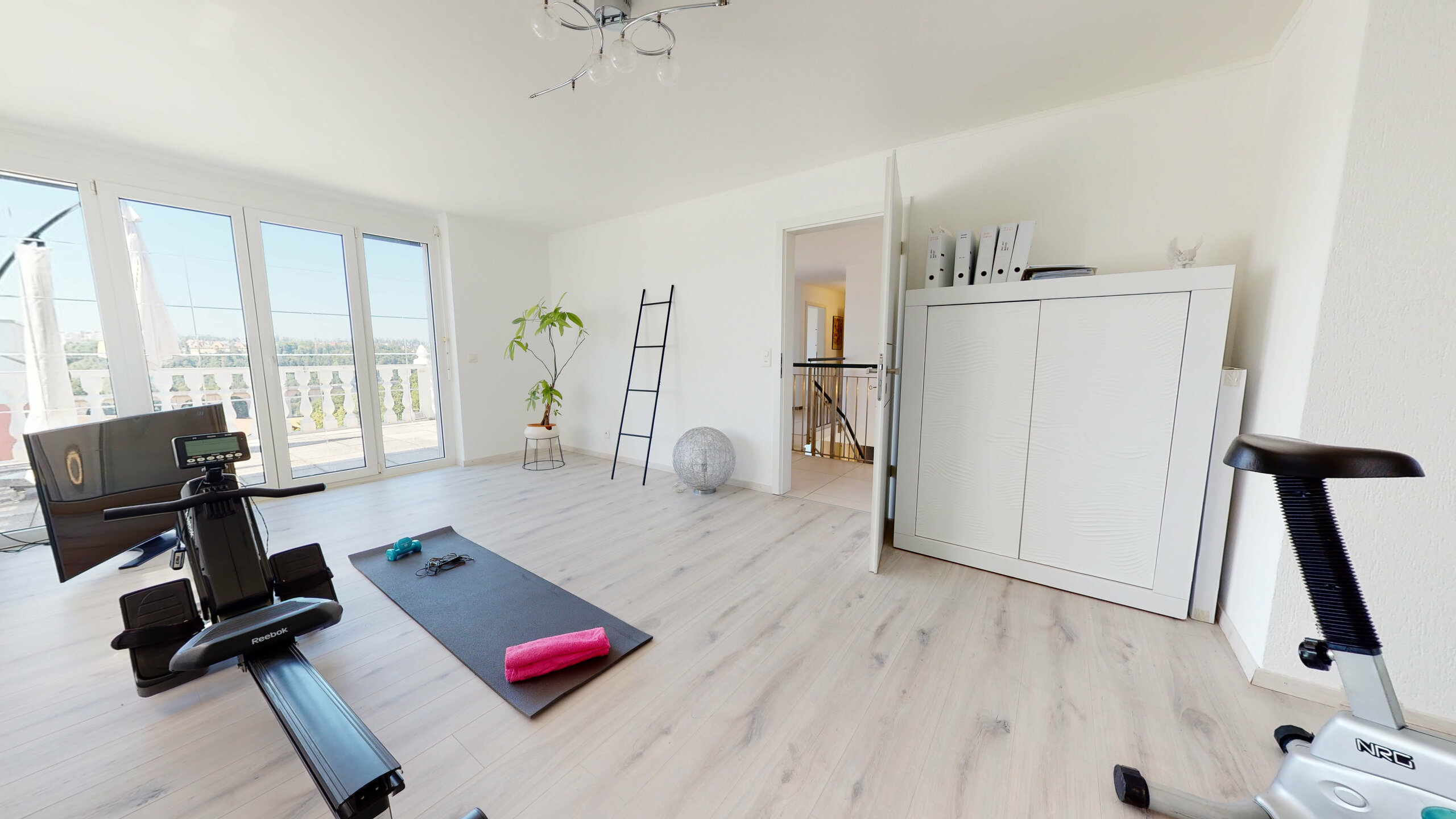 Helles Zimmer mit Balkonblick und Fitnessbereich