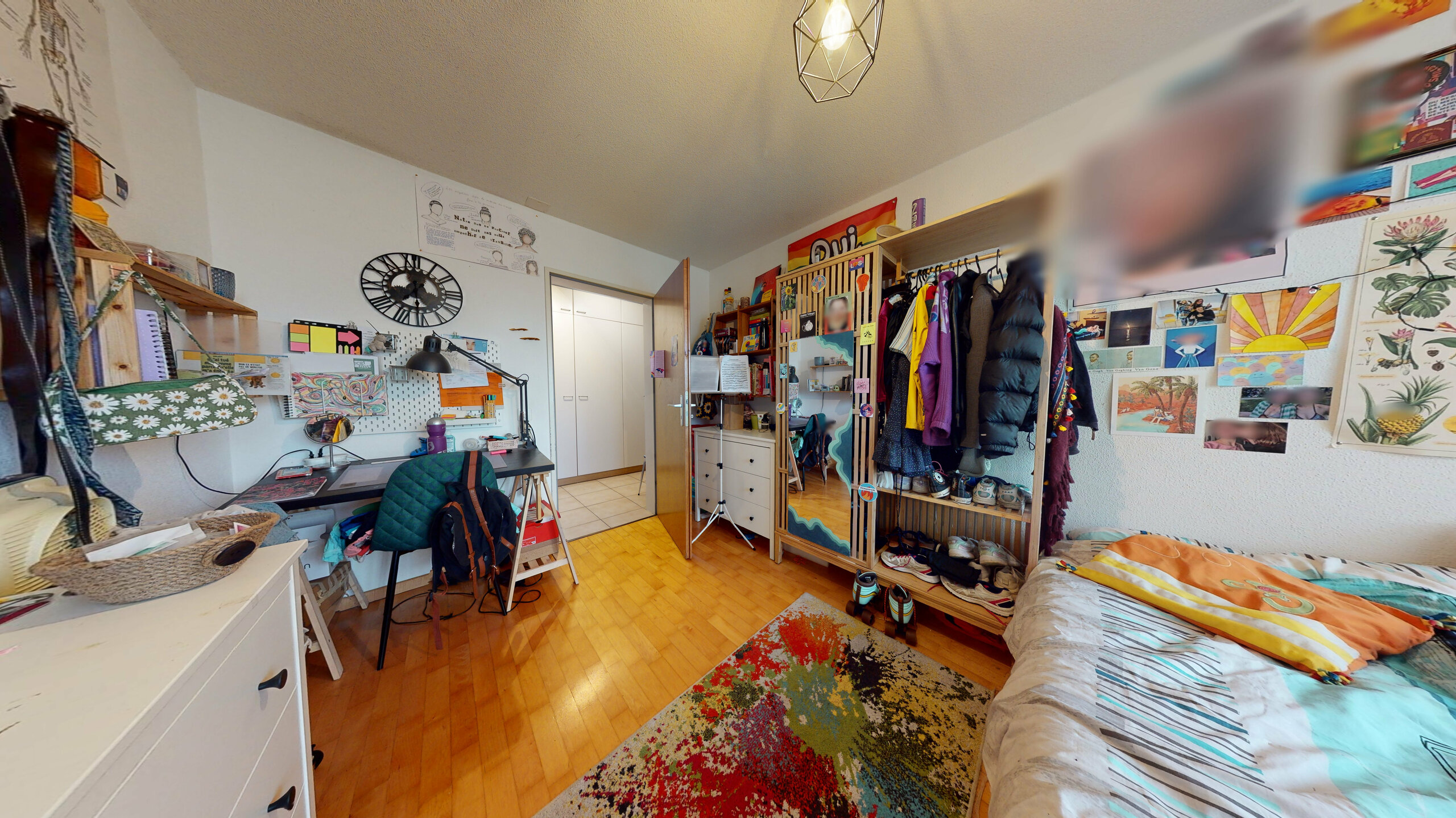 Bunt eingerichtetes Schlafzimmer mit Arbeitsbereich