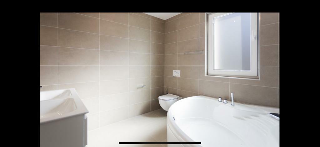 Modernes Badezimmer mit Badewanne und Fenster