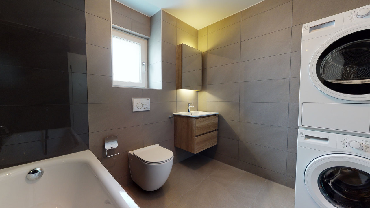 Modernes Badezimmer mit Waschtisch, WC, Badewanne und Waschturm