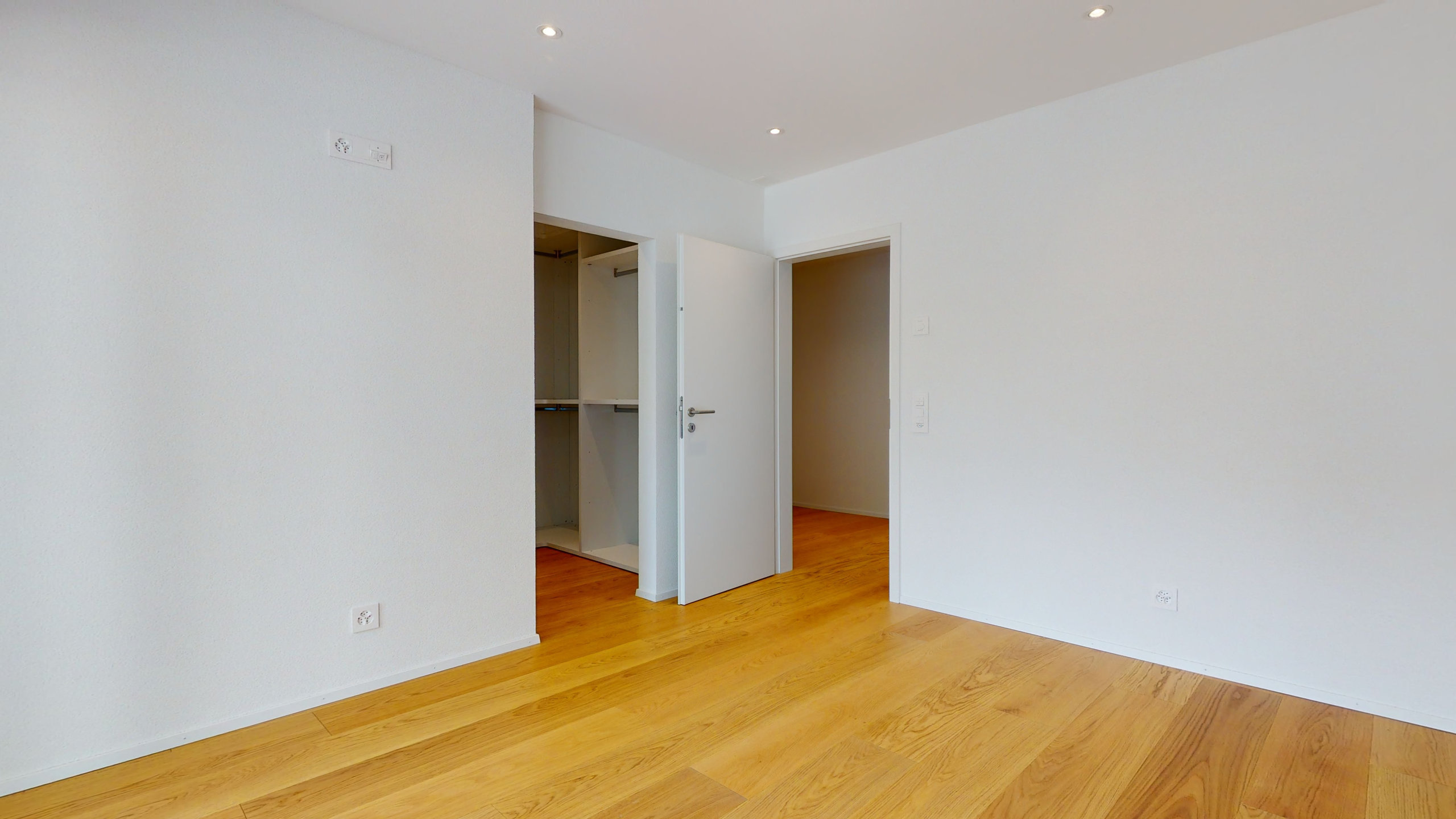 Helles, leeres Schlafzimmer mit Kleiderschrank