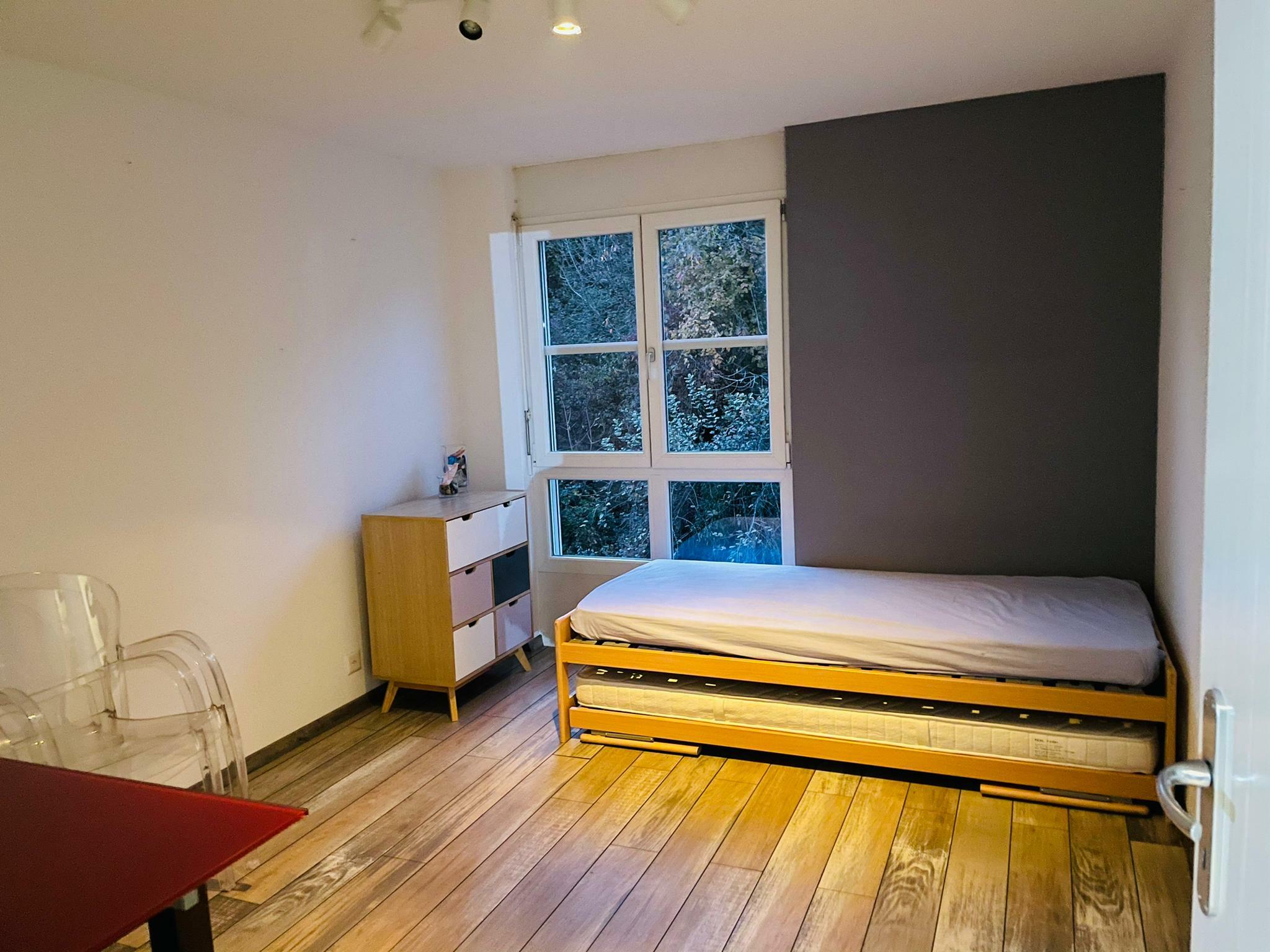 Schlafzimmer mit Einzelbett und Fensterblick