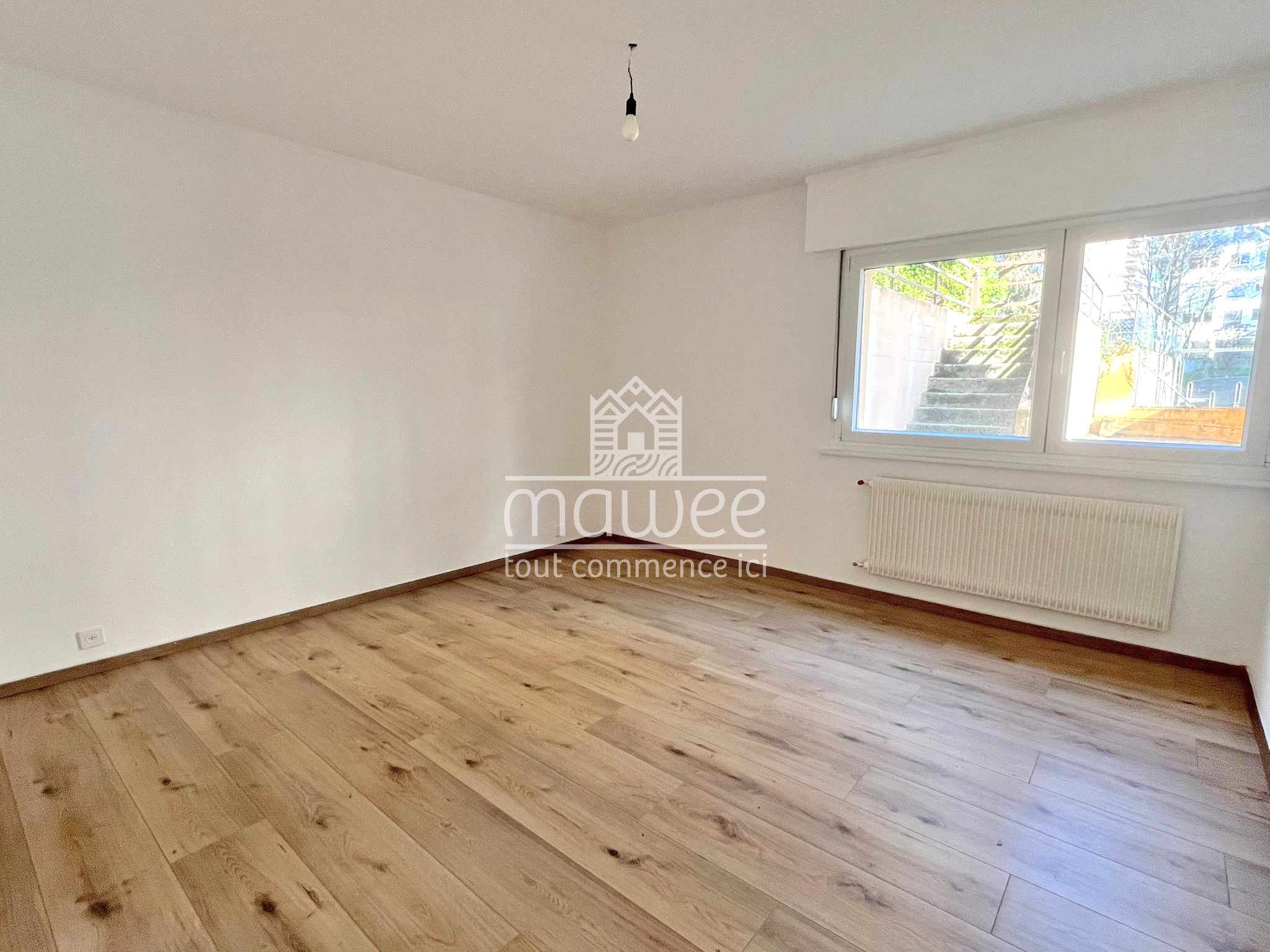 Leerer heller Raum mit Fenster und Heizkörper