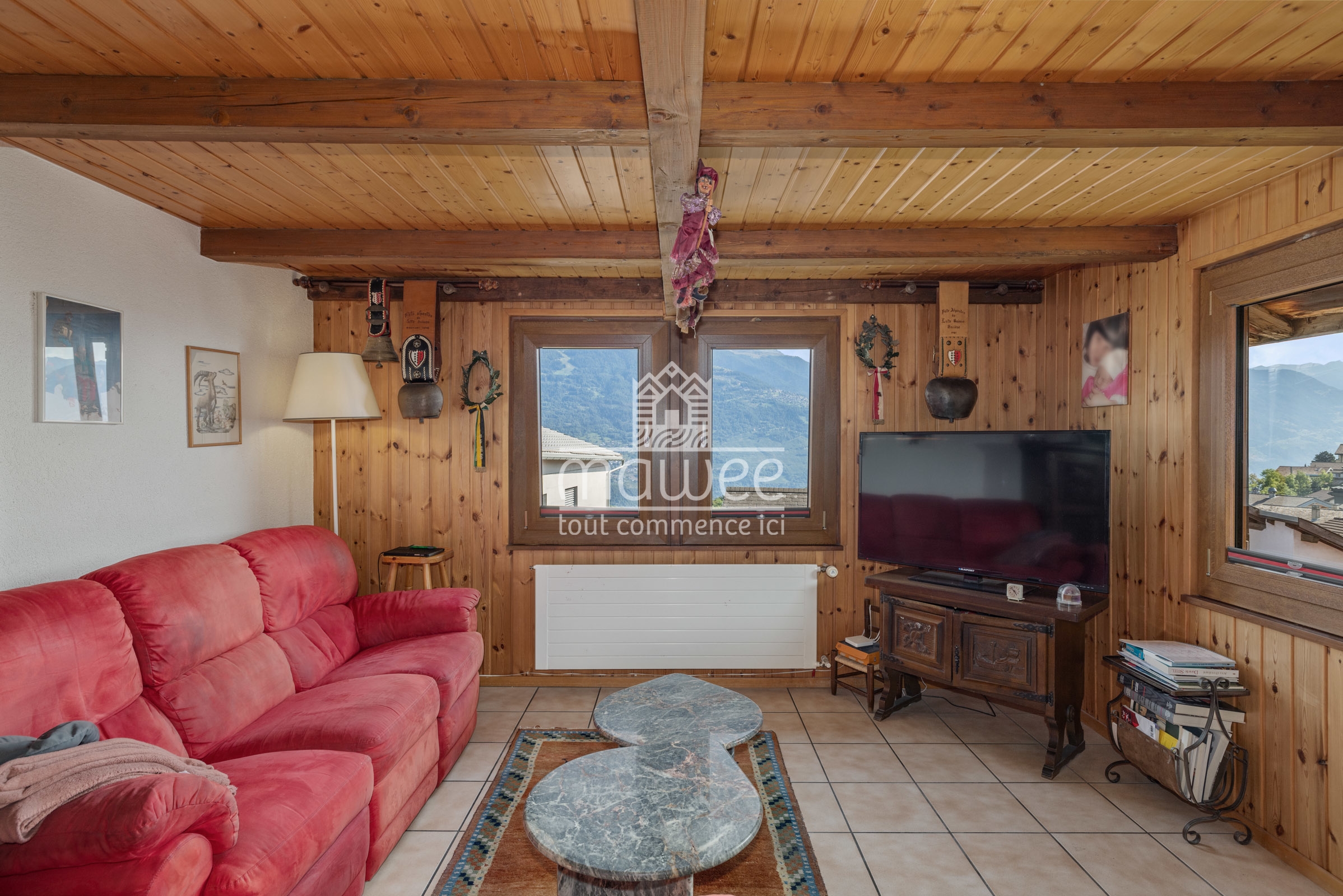 Gemütliches Wohnzimmer mit Holzverkleidung und Bergblick