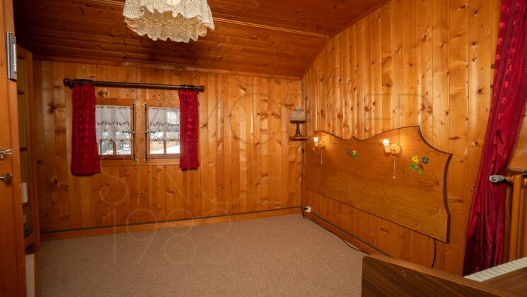 Rustikal verkleideter Raum mit Holzdecke