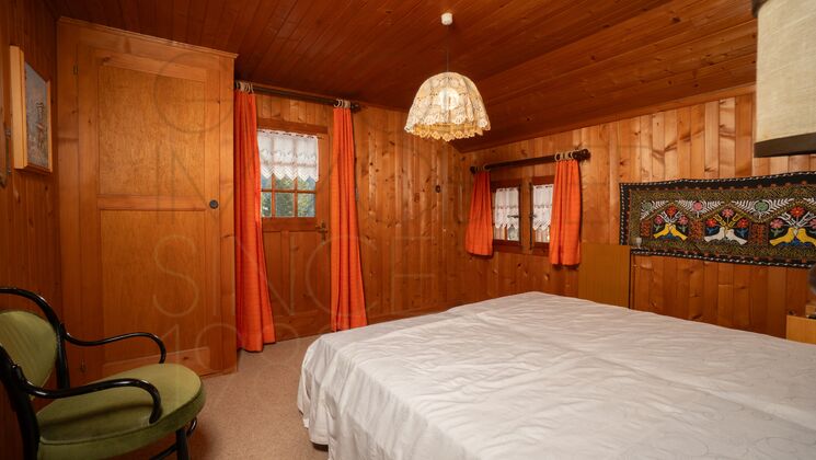 Rustikales Schlafzimmer mit Holzvertäfelung