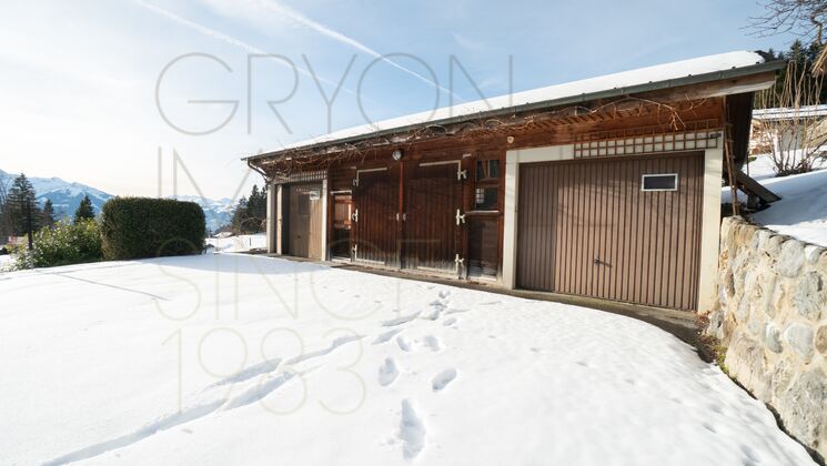 Schneebedeckte Garage mit Alpenblick