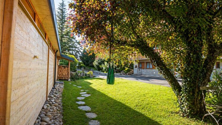 Garten mit Hausseite und großem Baum