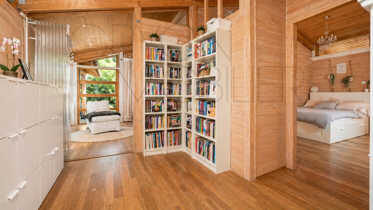 Holzinterieur mit Bücherregal und Schlafbereich