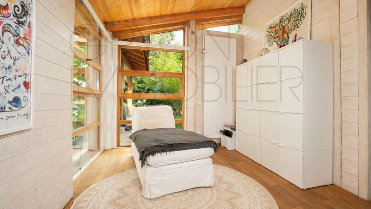 Helles Schlafzimmer mit großen Holzfenstern
