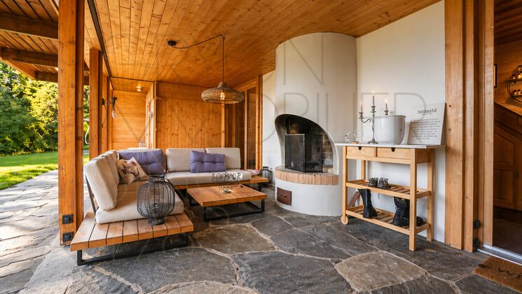 Überdachte Holzterrasse mit Kamin
