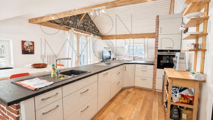 Offene Wohnküche mit sichtbaren Holzbalken