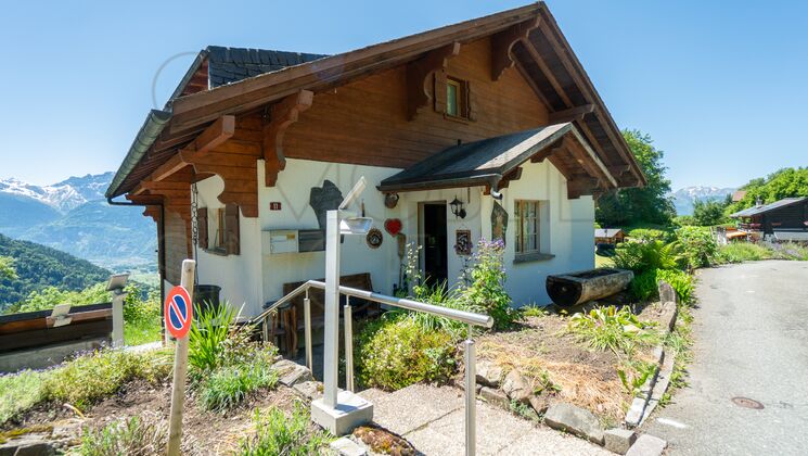 Berghaus mit Holzgiebel und Gartenzugang