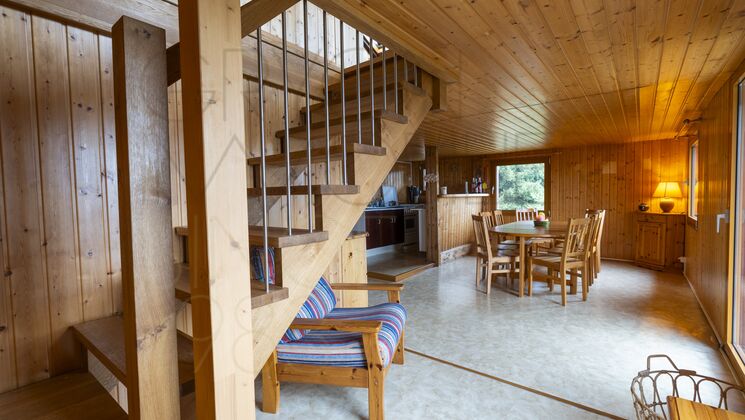 Holzverkleideter Wohnbereich mit Treppe und Essplatz